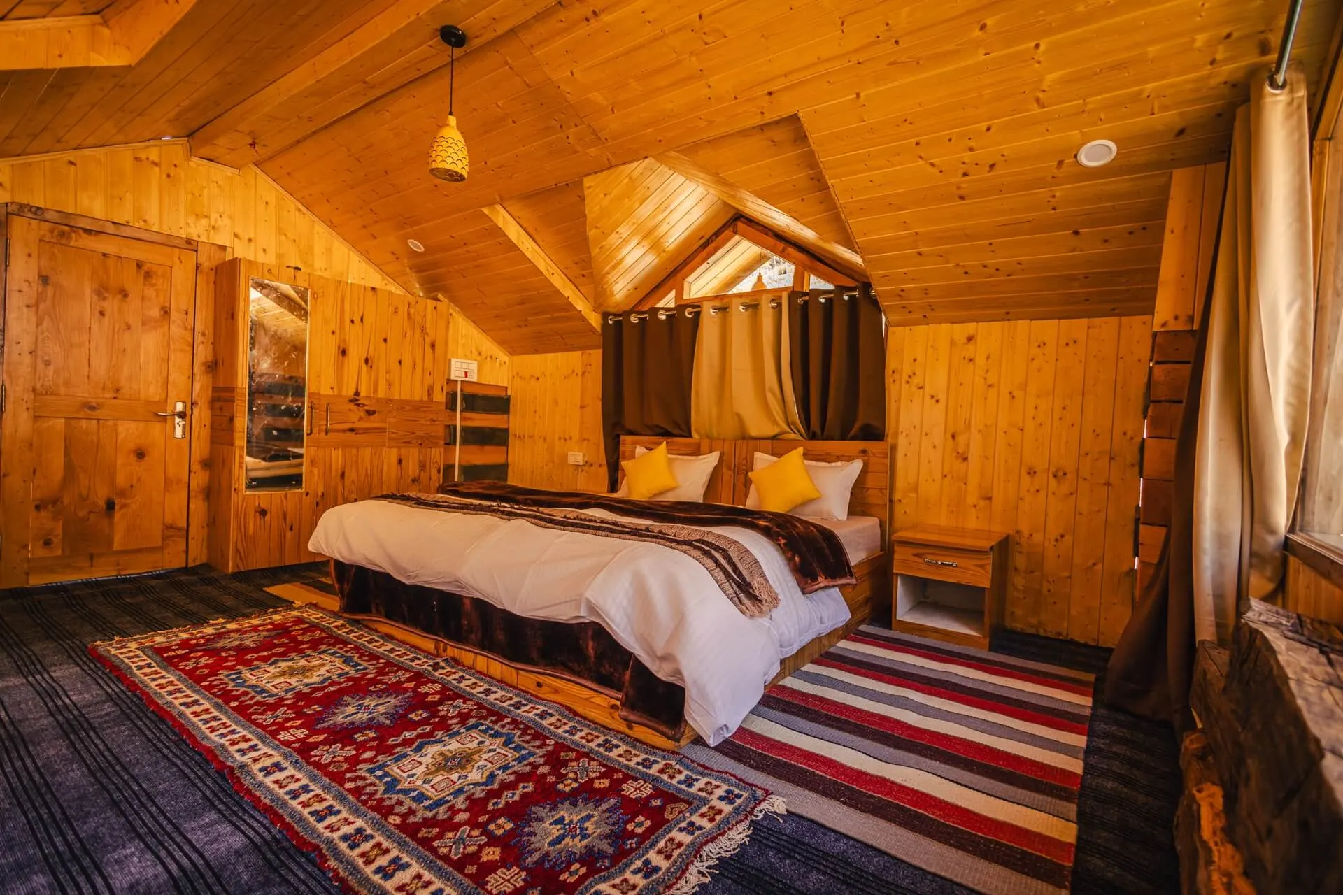 Moonhouse's wooden attic ceiling, queen bed and patterned rugs